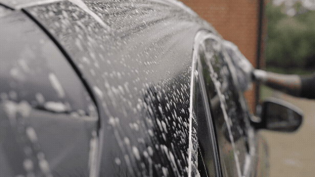 Microfibre wash mitt gliding over bonnet with soapy water