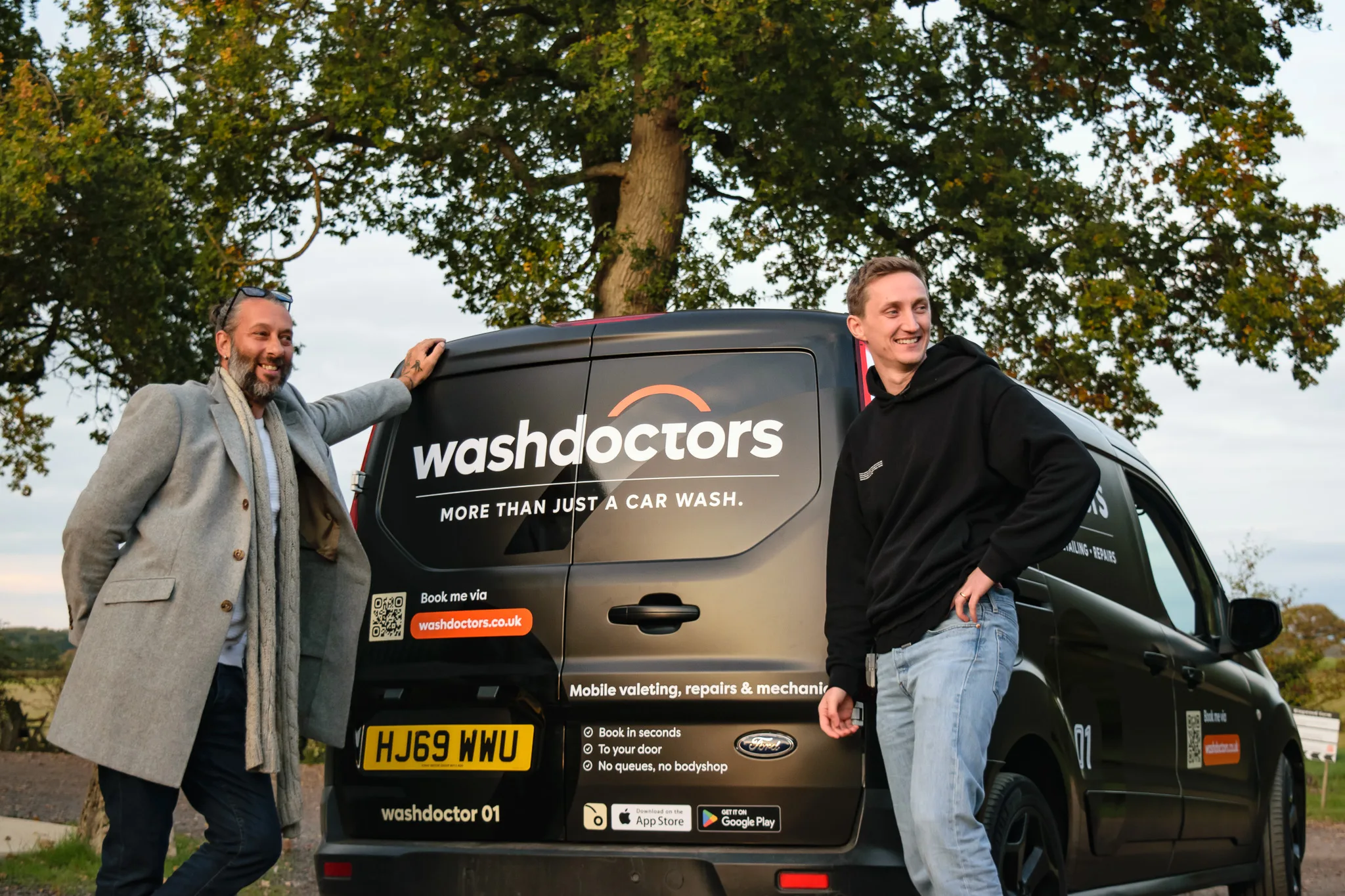 Two technicians with Washdoctors van ready for mobile car wash services.