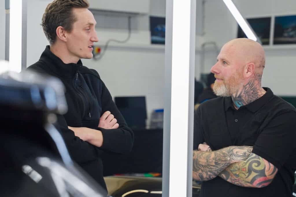 Two men having a discussion in a professional workshop environment.