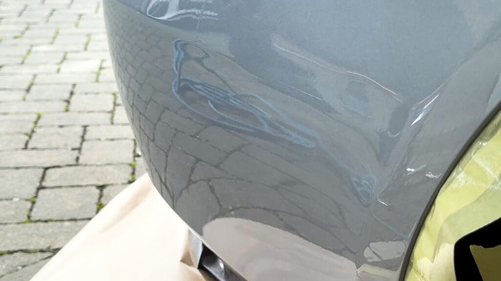 Close-up of a scuffed and scratched grey bumper corner before a mobile SMART repair